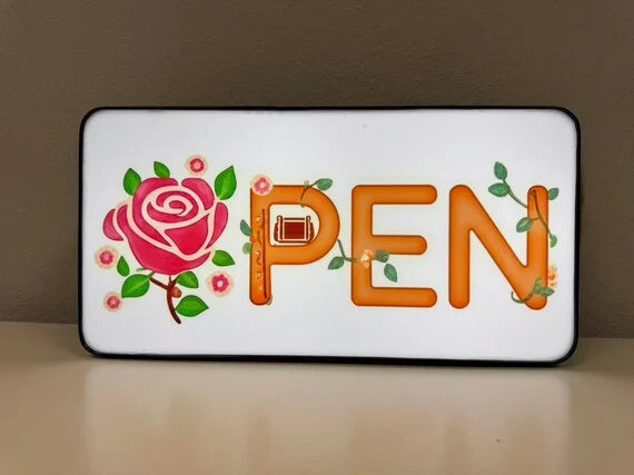 An illuminated OPEN light box with a printed face.