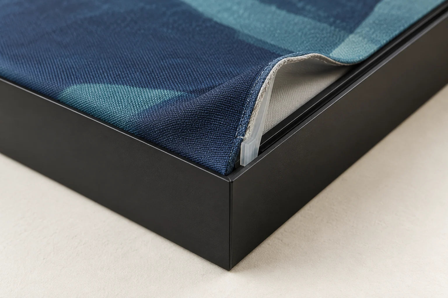 Close-up of a silicone strip sewn along the fabric edge, seated in the frame channel.